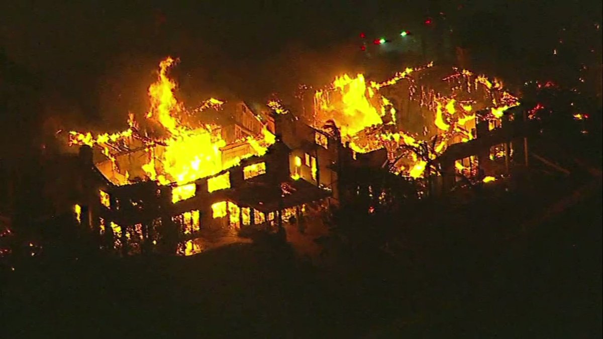 Fire officials believe a total of 20 structures in a neighborhood near Laguna Beach were destroyed Wednesday as a fast-moving brush fire spread rapidly amid strong winds