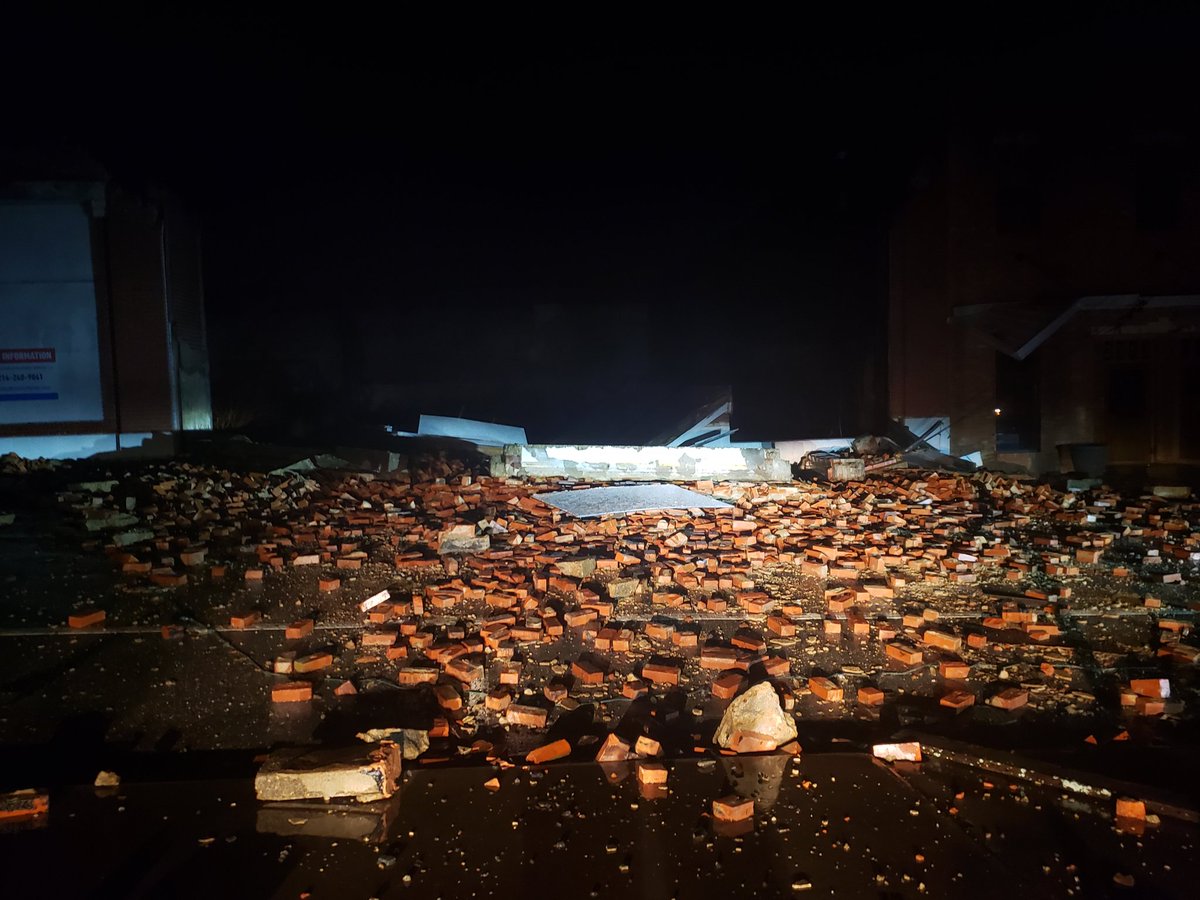 Multiple brick buildings collapsed in downtown Greenville with roads blocked by debris